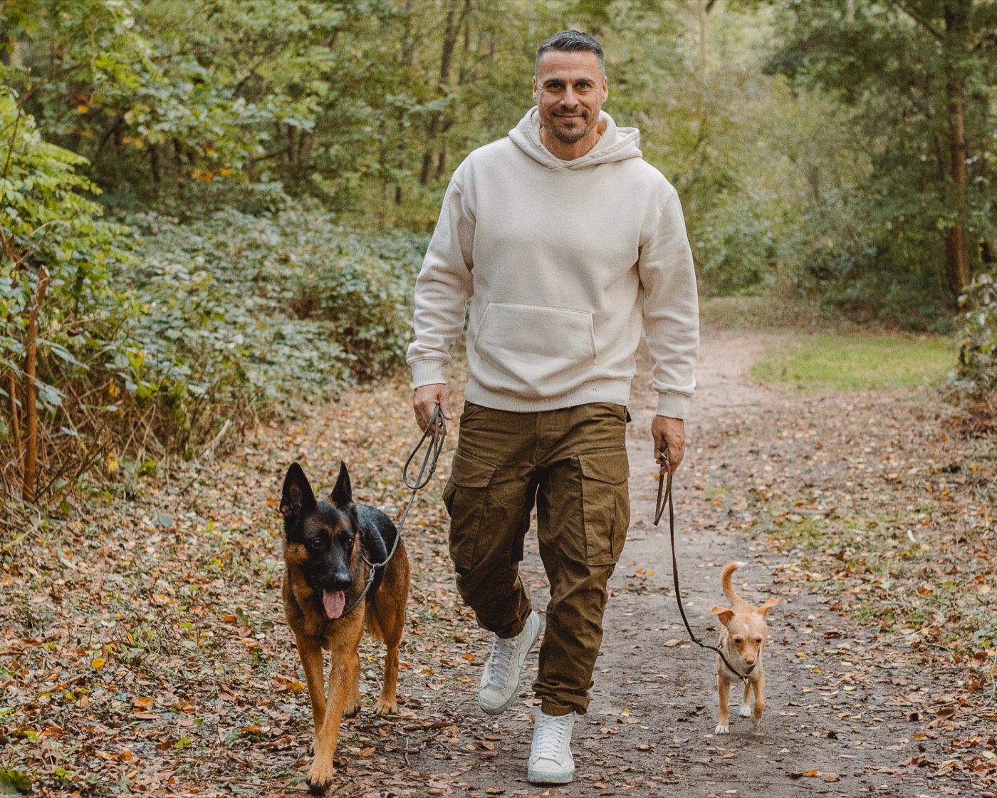 Timo Staffeldt geht mit seinen beiden Hunden auf einem Waldweg